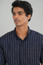 A model wearing a navy blue striped linen cotton mixed shirt with short sleeves, a chest pocket, and a relaxed fit, ideal for casual summer outings or refined everyday styling.