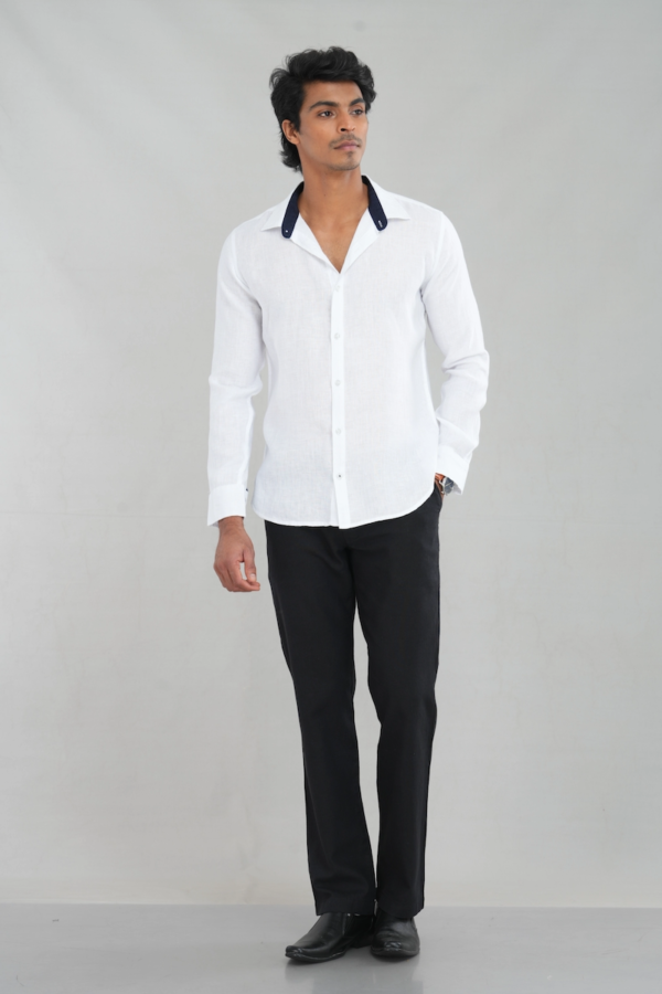 A model wearing a Classic White Linen shirt with a contrasting navy collar and long sleeves, perfect for casual summer wear or refined everyday styling.