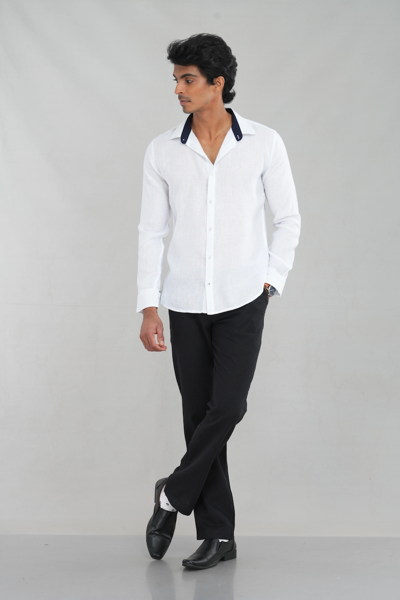 A model wearing a Classic White Linen shirt with a contrasting navy collar and long sleeves, perfect for casual summer wear or refined everyday styling.