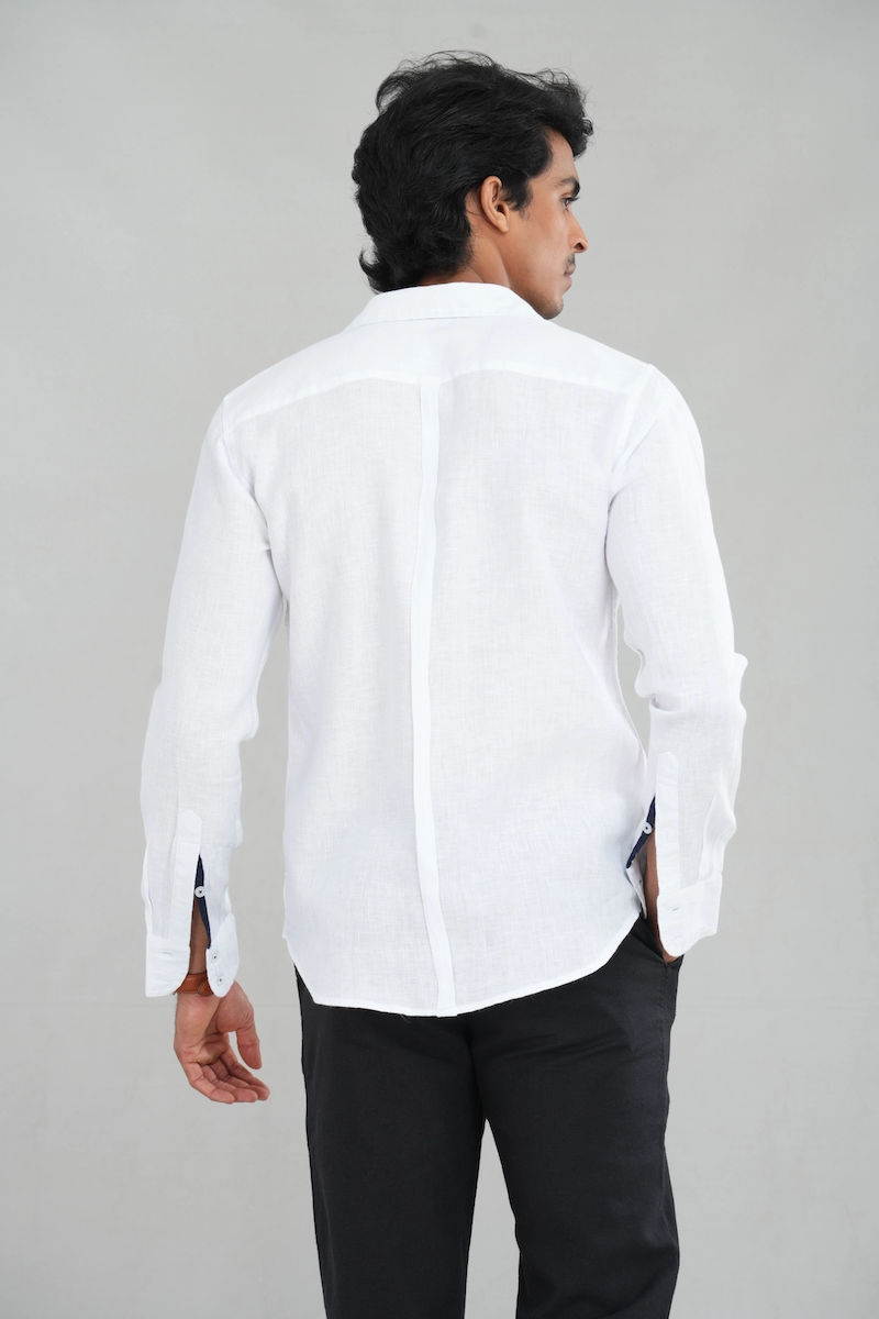 A model wearing a Classic White Linen shirt with a contrasting navy collar and long sleeves, perfect for casual summer wear or refined everyday styling.