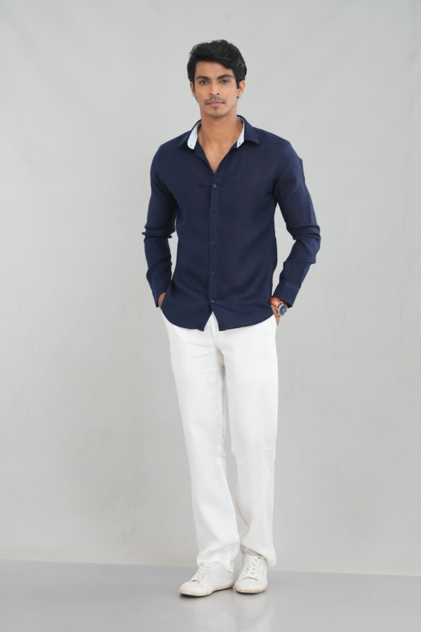 A model wearing a long sleeve linen shirt in a deep navy blue shade, featuring a classic button-up design and lightweight fabric, perfect for casual summer wear or stylish everyday outfits.