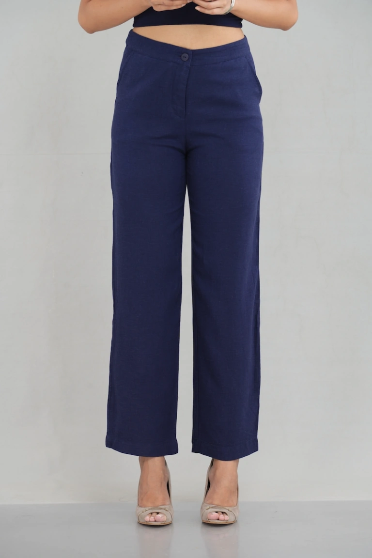 A pair of midnight blue straight-leg trousers crafted from cotton, paired with neutral heels, offering a sophisticated and comfortable style for casual and semi-formal settings.