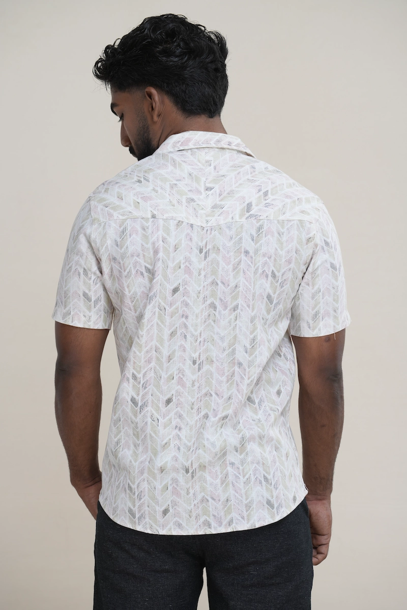 Man wearing a light multi-color chevron print Cuban collar short sleeve shirt with coconut buttons.