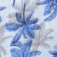 Man wearing a white cotton short sleeve shirt with a white and blue palm tree print, classic collar, and coconut buttons