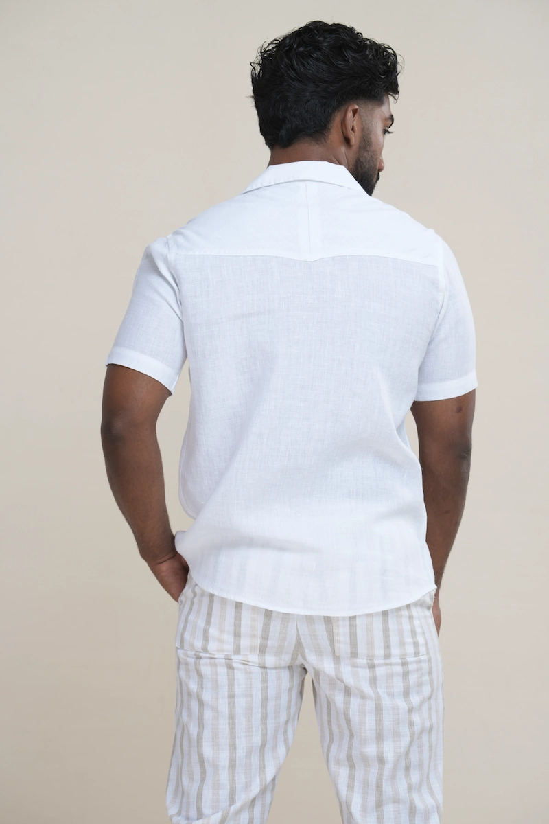 Close-up of a men's classic white linen Cuban collar short sleeve shirt with matching white buttons.