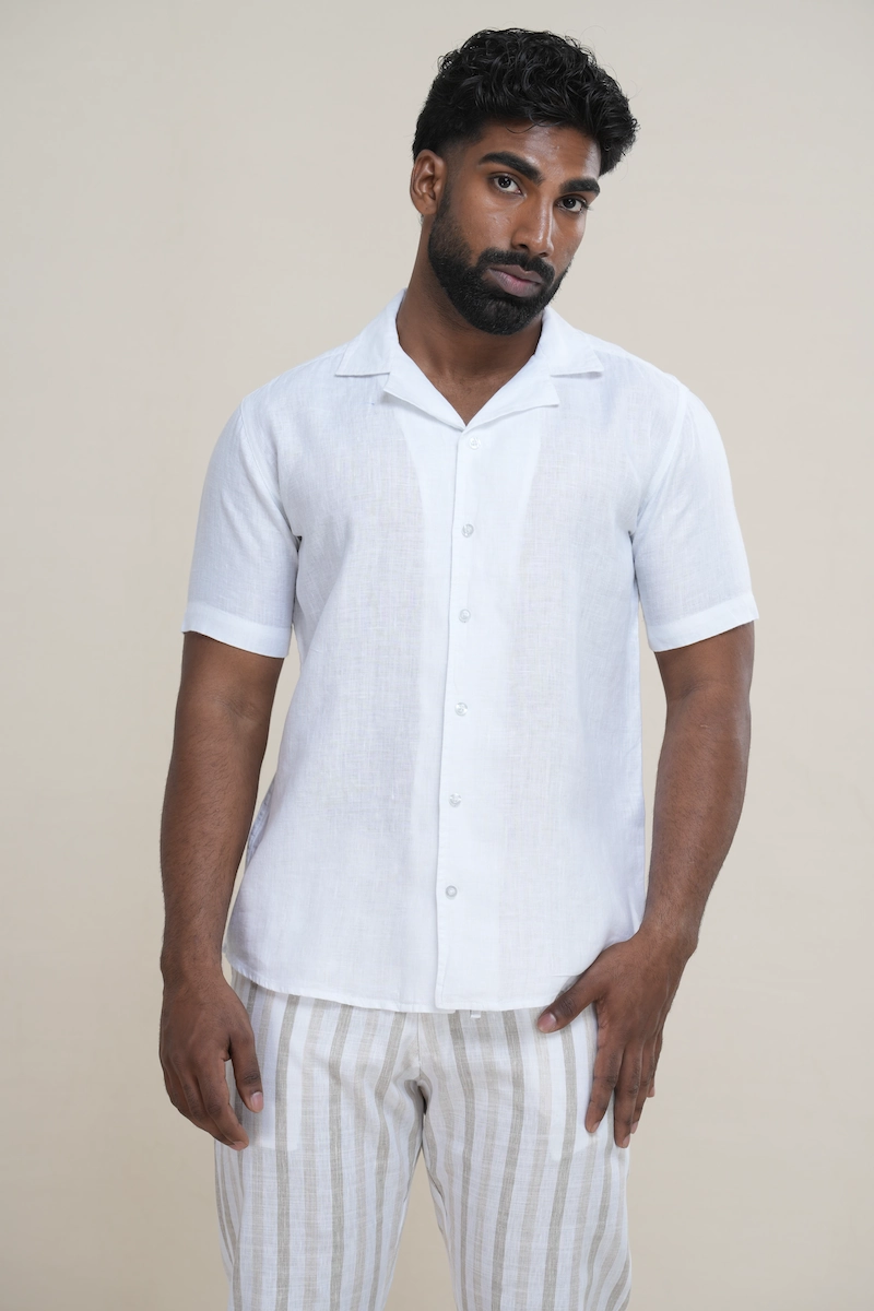 Close-up of a men's classic white linen Cuban collar short sleeve shirt with matching white buttons.