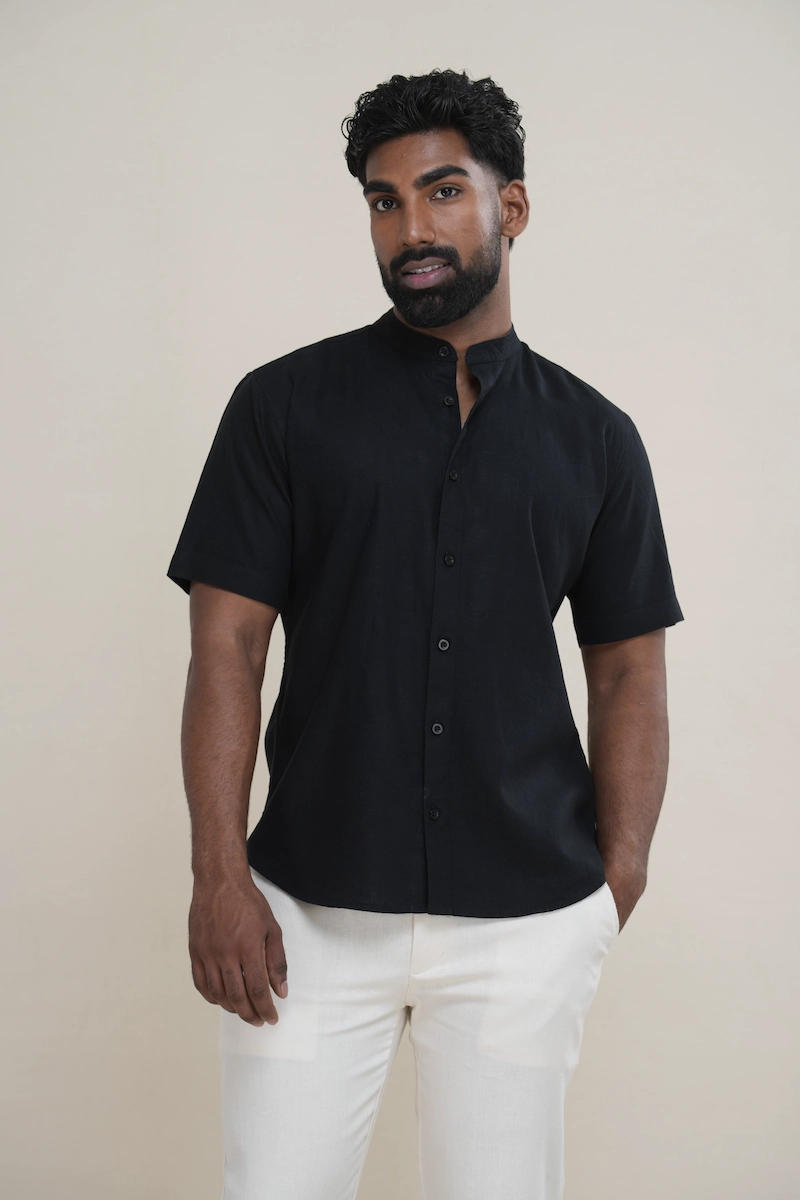 Man wearing a jet black linen short sleeve Mandarin collar shirt with matching buttons
