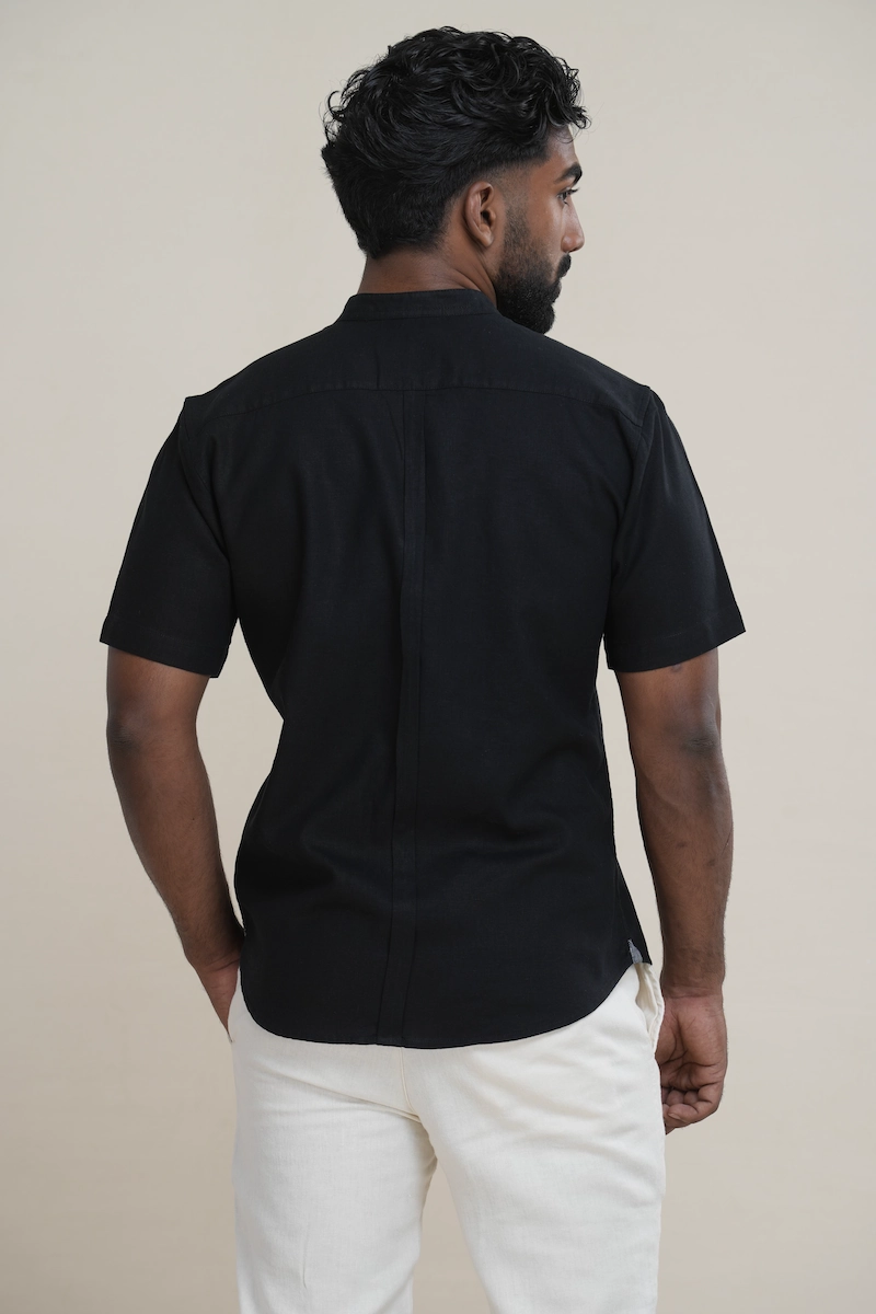 Man wearing a jet black linen short sleeve Mandarin collar shirt with matching buttons