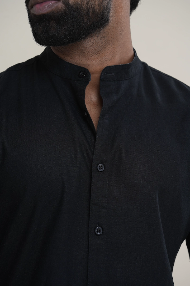 Man wearing a jet black linen short sleeve Mandarin collar shirt with matching buttons