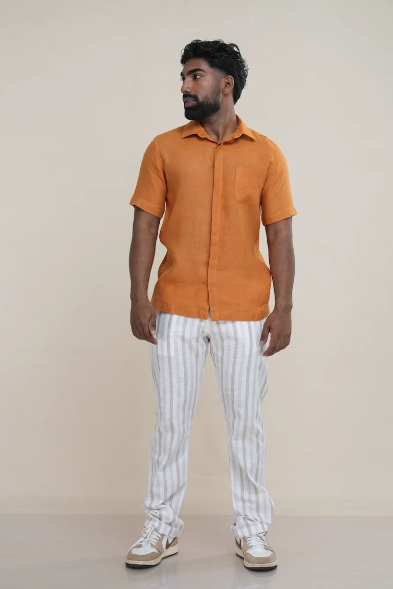 Man wearing a rust brown linen short sleeve shirt with a double placket and chest pocket.