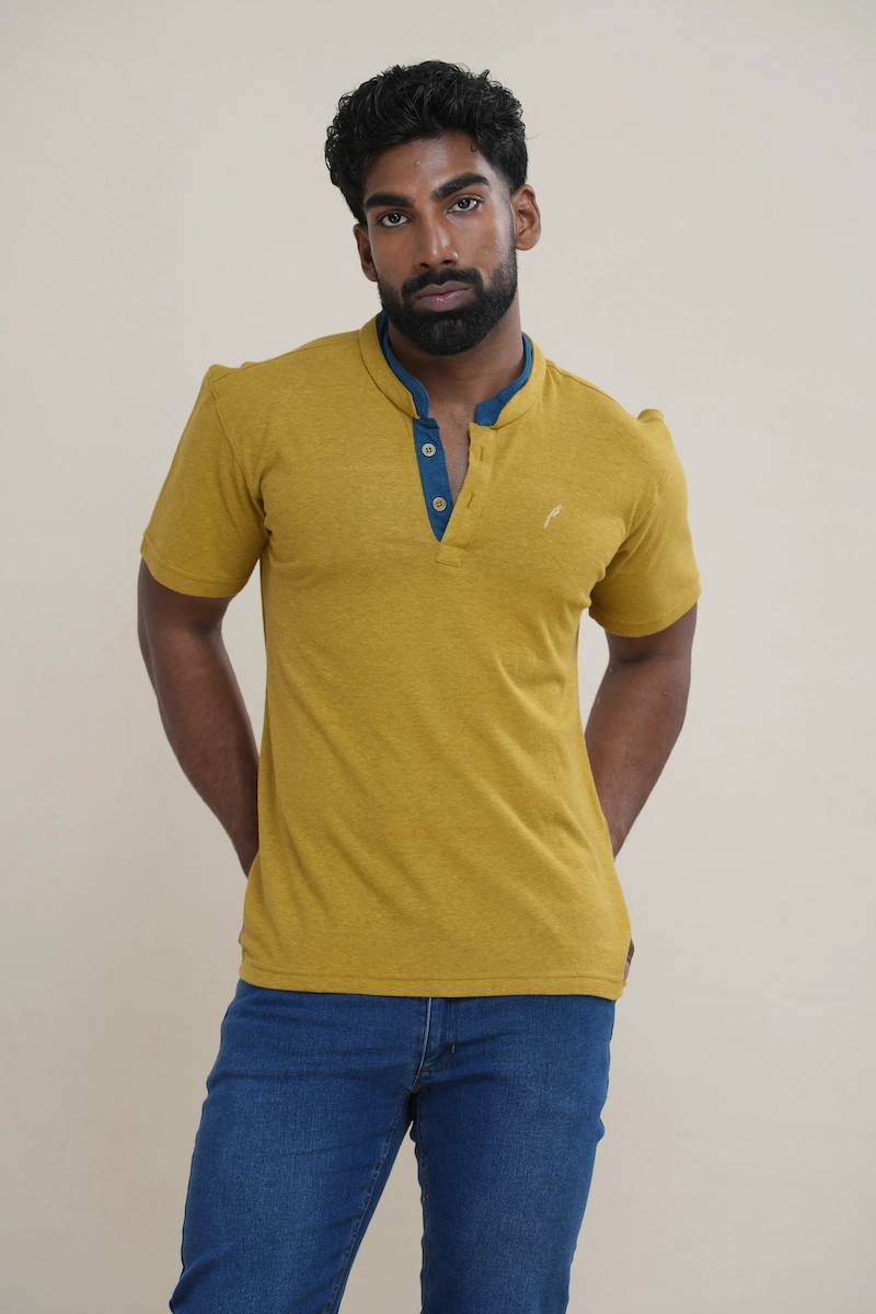 Close-up of a men's heathered moss green cotton jersey layered collar Henley shirt with blue inner collar detail, two buttons, and an embroidered parrot logo.