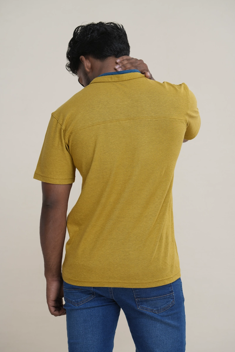 Close-up of a men's heathered moss green cotton jersey layered collar Henley shirt with blue inner collar detail, two buttons, and an embroidered parrot logo.