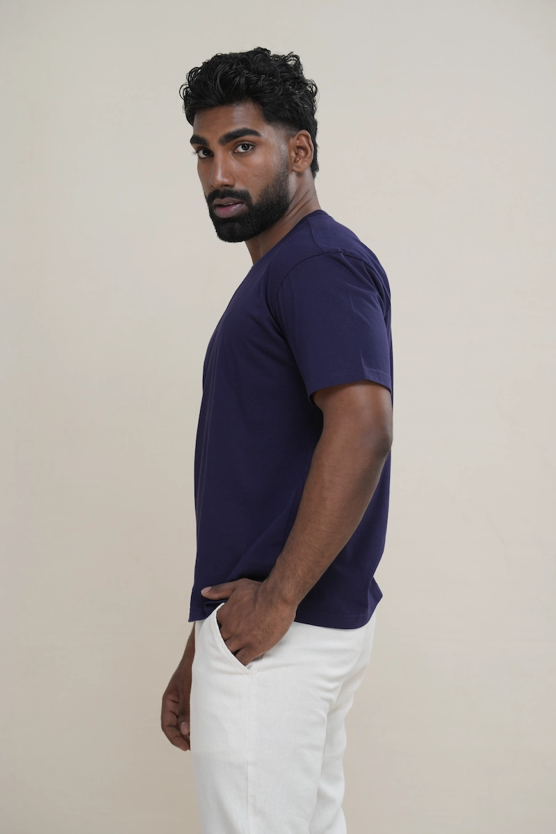 Man wearing a navy blue classic crew neck t-shirt with embroidered parrot logo.