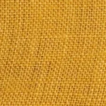 Woman wearing a mustard yellow linen Mandarin collar halter top with matching fabric-covered buttons.