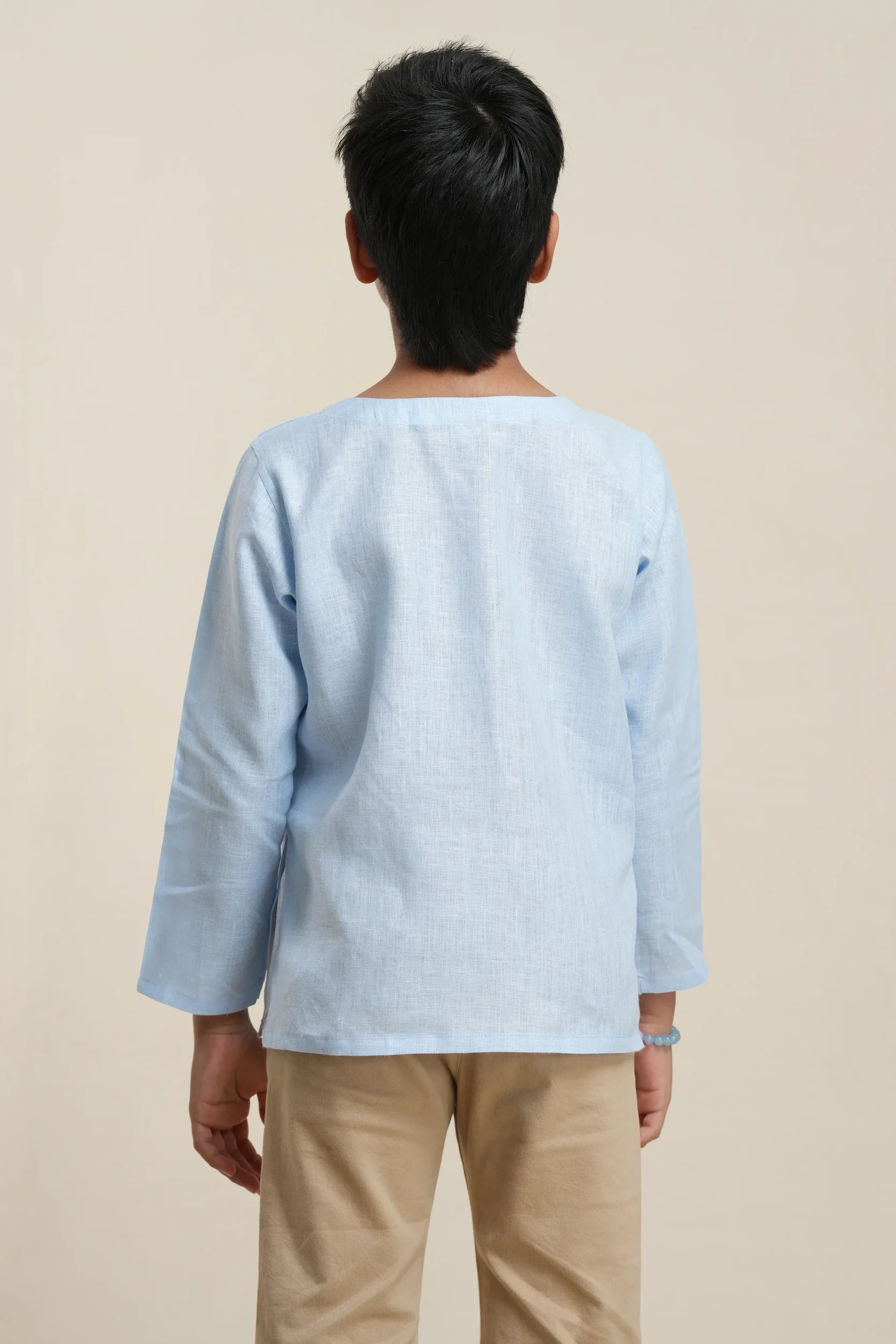 Back view of boys' long sleeve kurta in sky blue linen, showing relaxed fit and natural fabric texture on model