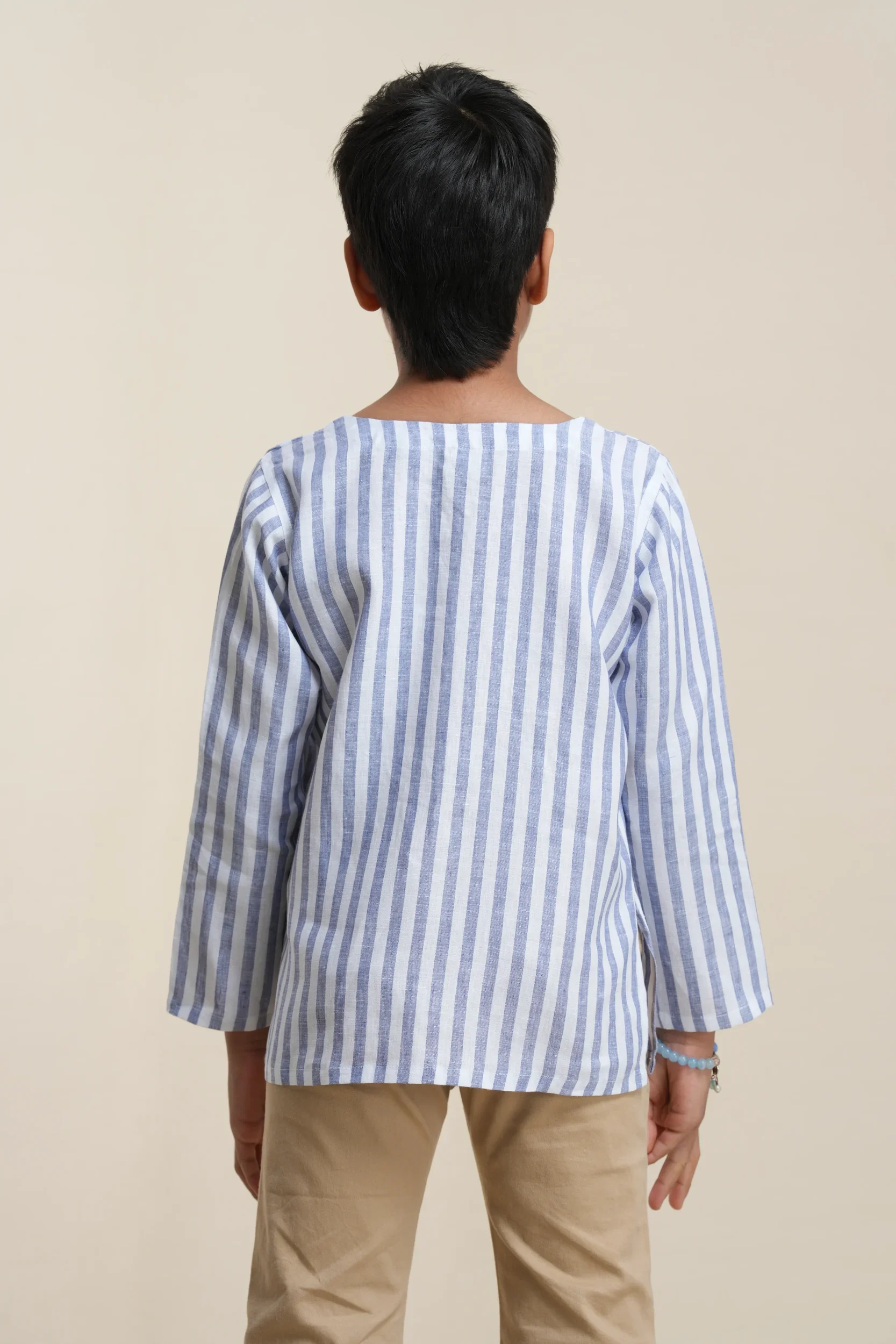 Back view of boys' long sleeve linen kurta in blue and white vertical stripes, showing relaxed fit and boat neckline