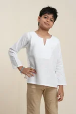 Young boy modeling white tonal stripe long sleeve linen kurta with notch neckline, paired with tan pants on beige background