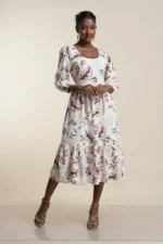 Front view of women's tiered midi dress in white with pink and blue botanical print, cotton blend fabric, three-quarter sleeves