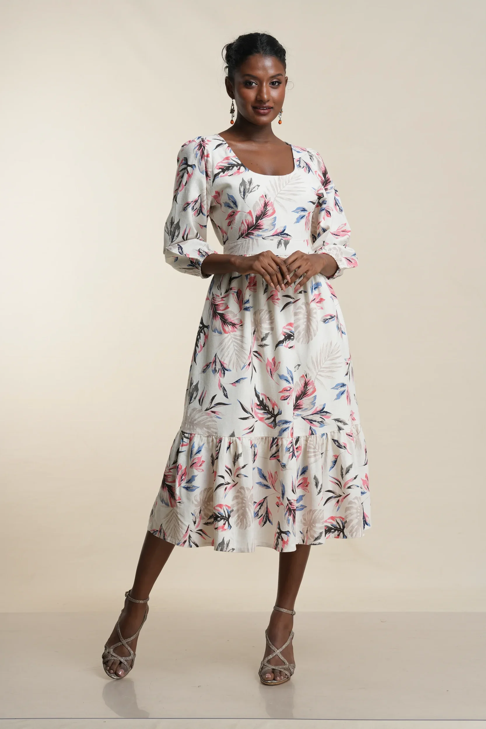 Front view of women's tiered midi dress in white with pink and blue botanical print, cotton blend fabric, three-quarter sleeves