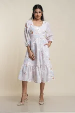 Front view of women's tiered midi dress in white and lilac floral print cotton blend with puff sleeves and ruffle hem