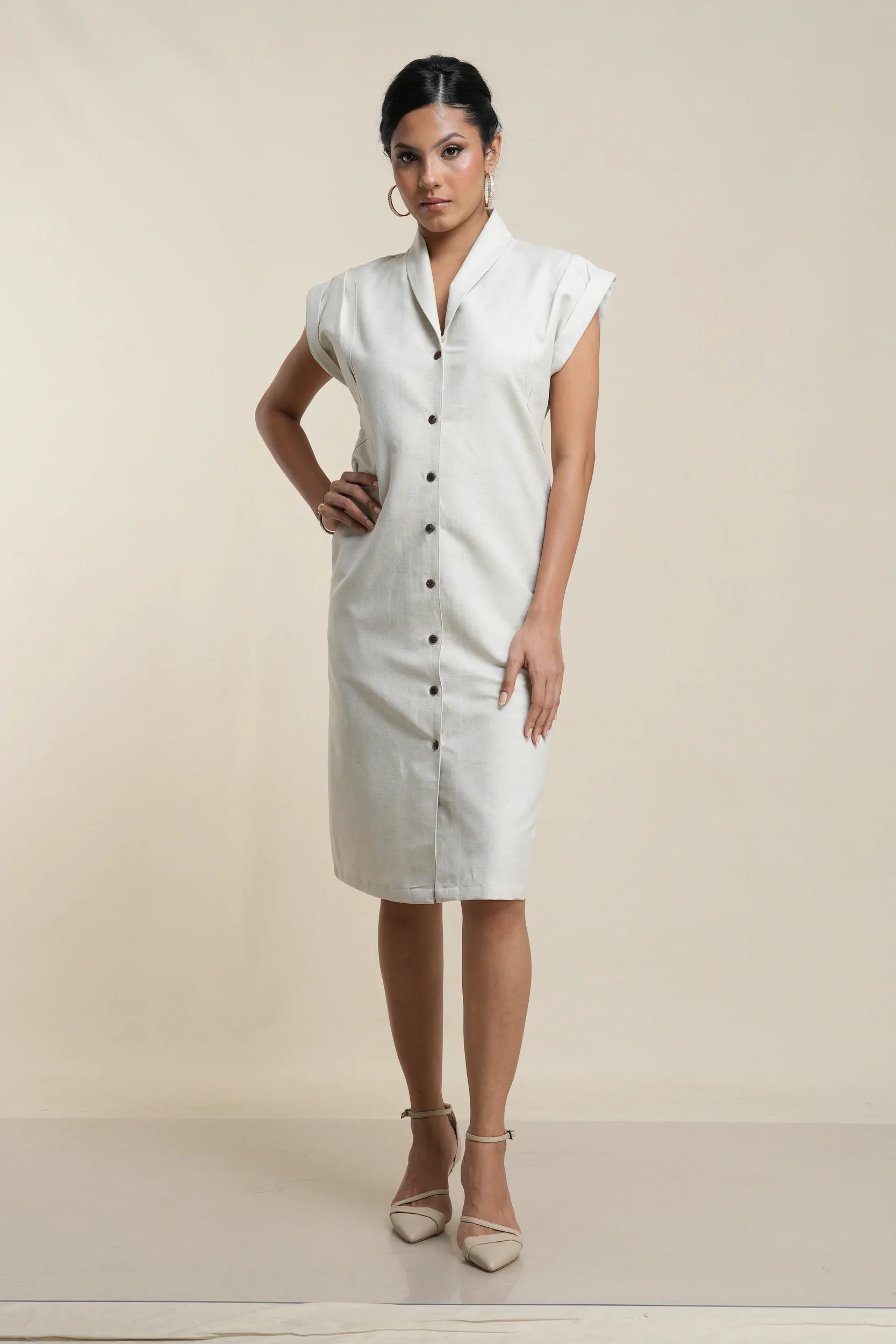 Front view of ecru linen cotton blend button-front shirt dress with collar, cap sleeves, and knee-length cut on model