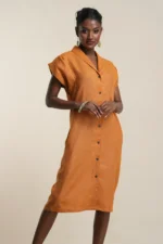 Model wearing rust orange linen button-front shirt dress with collar, short sleeves, and knee-length hemline