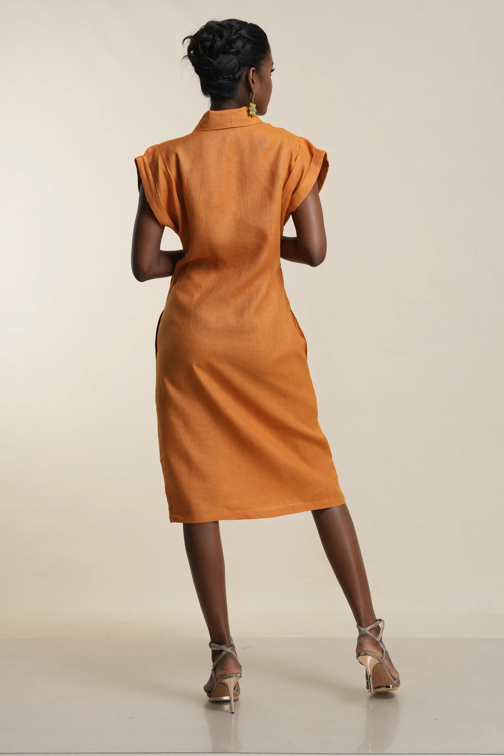 Back view of women's rust orange linen shirt dress with cap sleeves, collar detail, knee-length silhouette