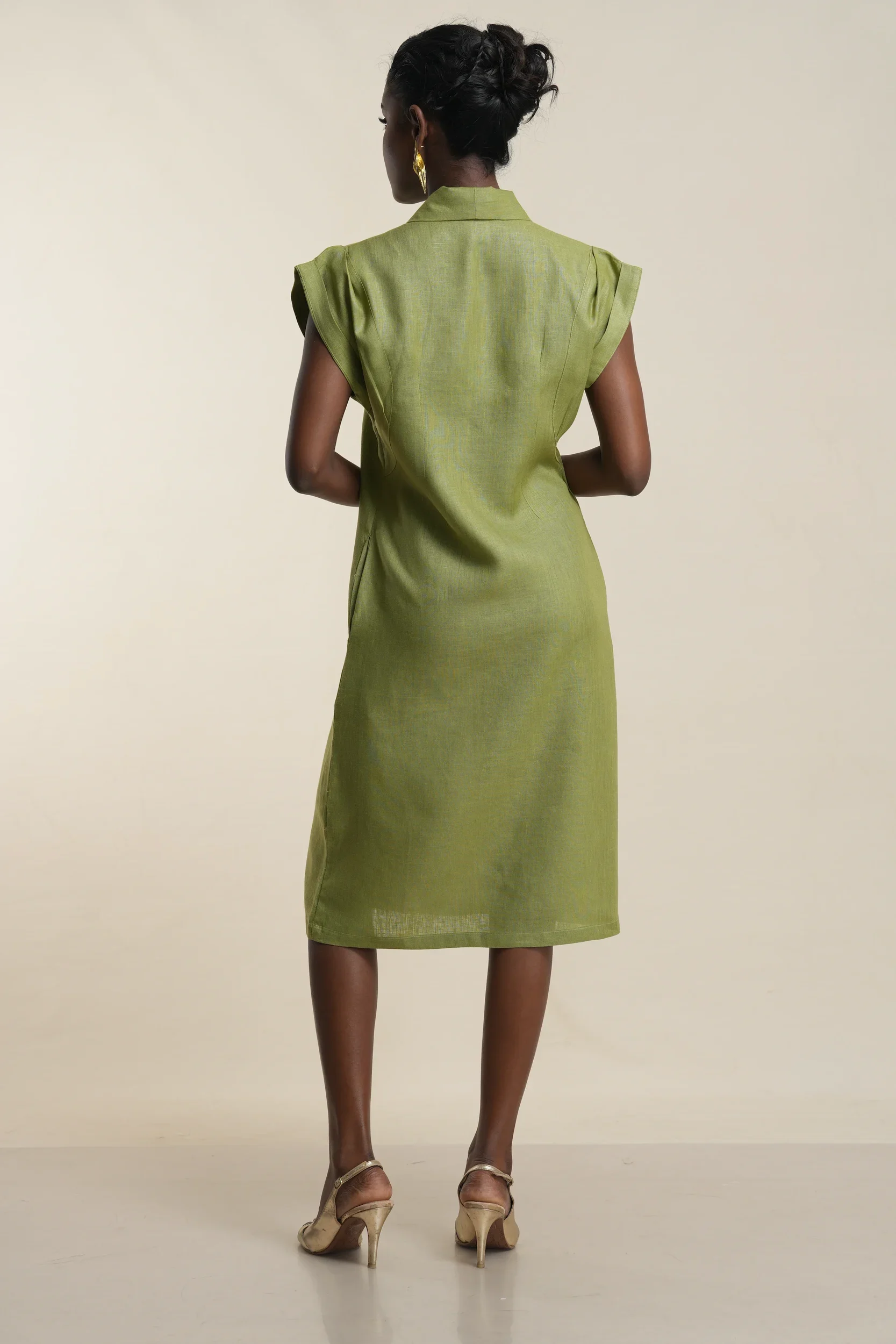 Back view of women's olive green linen shirt dress with collar, cap sleeves, and knee-length silhouette on model
