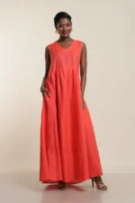 Women's sleeveless maxi dress in soft coral red linen, V-neck with collar detail, empire waist, flowing A-line silhouette